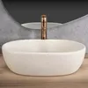 A close-up view of a modern bathroom sink with a gold faucet. Produktbild-Vorschau