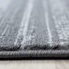 A close-up, low-angle shot of a gray rug with a subtle linear pattern, resting on a light wooden floor. Produktbild-Vorschau
