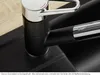 A close-up view of a black and chrome kitchen faucet with a pull-out spray hose, set against a black sink and a wooden countertop. Produktbild-Vorschau