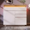 A modern white sideboard with a wooden top and LED lighting, placed in a living room setting. Podgląd zdjęcia produktu