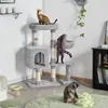 Three cats are interacting with a multi-level cat tree in a room setting.