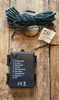 A bundle of LED string lights and their battery pack are laid out on a wooden surface. Produktbild-Vorschau
