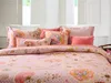 A close-up view of a bed with floral patterned bedding and pillows. Produktbild-Vorschau