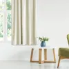 A cream-colored curtain hangs next to a window, with a small white table and a blue vase with flowers in front of it. Podgląd zdjęcia produktu