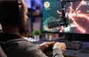 A person wearing headphones is playing a video game while using a microphone. Produktbild-Vorschau