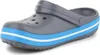 A single gray Crocband shoe with blue and white stripes on the sole, shown against a white background. Produktbild-Vorschau