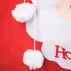 A close-up of a red Christmas sack with white felt decorations and two white pom-poms hanging from a string. Anteprima dell’immagine prodotto