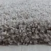 A close-up view of a shaggy rug with a light-colored wooden floor visible underneath. Anteprima dell’immagine prodotto