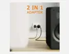 A white electrical outlet with two black plugs inserted, connected to a speaker. Text overlay indicates '2 IN 1 ADAPTER'. Produktbild-Vorschau