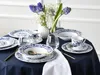 A table set for a meal with blue and white floral patterned dishes, cutlery, glasses, and a vase of flowers. Náhľad obrázku produktu