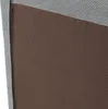 A close-up view of a textured fabric surface, likely part of a floor chair or cushion, showing a brown perforated section meeting a gray woven section. Náhled obrázku produktu