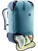 A close-up view of a teal and gray Deuter backpack with a shoe compartment open at the bottom, revealing a pair of white and neon green athletic shoes. Voir les images du produit