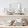 A collection of white porcelain dinnerware is neatly arranged on two shelves against a white background. Produktbild-Vorschau