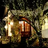 A house entrance decorated with Christmas lights and greenery. Podgląd zdjęcia produktu