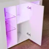 A white high-gloss cabinet with open doors, revealing purple LED lighting inside and glass shelves. Produktbild-Vorschau