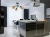 A modern kitchen and dining area with a black chandelier, a kitchen island with a stovetop, and a dining table with chairs. Produktbild-Vorschau