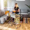 A woman is hanging clothes on a drying rack in a living room. Náhľad obrázku produktu