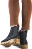 A close-up shot of a person's legs wearing brown pants and blue Chelsea boots. Produktbild-Vorschau