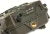 Close-up of the side of a camouflage-patterned electronic device, showing a power port and a threaded mounting hole. Produktbild-Vorschau