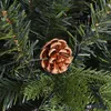 A close-up view of a pine cone on a Christmas tree with lights. Produktbild-Vorschau