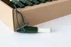 A close-up shot of a single light bulb with a green clip and a cardboard box in the background. Produktbild-Vorschau