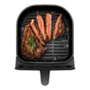 A top-down view of an air fryer basket filled with sliced steak and a sprig of rosemary. Produktbild-Vorschau