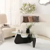 A modern living room scene featuring a couch, armchair, and a unique coffee table. Produktbild-Vorschau