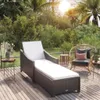 A sun lounger and chair on a wooden deck surrounded by lush greenery and palm trees, with the sun shining. Náhľad obrázku produktu