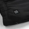 Close-up of a black garment with a power button icon and a zipper. Podgląd zdjęcia produktu