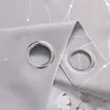 A close-up view of two grommets on a light gray curtain with a silver geometric pattern. Produktbild-Vorschau