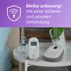 A baby monitor set is displayed on a white side table, with a purple overlay at the top featuring a shield icon and text. Produktbild-Vorschau