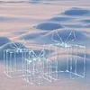 Three illuminated gift boxes sitting in the snow. Podgląd zdjęcia produktu