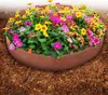 A close-up of a planter filled with colorful flowers, placed on the ground. Podgląd zdjęcia produktu