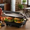 A kitchen counter with a grill and burgers. Produktbild-Vorschau