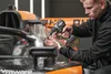 A person is using a Dewalt drill on a race car. Voir les images du produit
