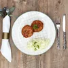 A plate of food with cutlery and a napkin on a wooden table. Náhled obrázku produktu
