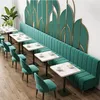 A long, green upholstered bench seat with tables and chairs in a cafe or restaurant setting. Anteprima dell’immagine prodotto