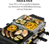 A raclette grill with various foods being cooked on it, including sausages, chicken, vegetables, and peppers. The grill has two different cooking surfaces: a stone plate and a non-stick aluminum plate. Produktbild-Vorschau