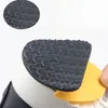 A close-up of a black anti-slip shoe sole protector being applied to the bottom of a shoe. Voir les images du produit