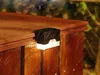 A solar-powered garden light attached to a wooden fence in the rain. Podgląd zdjęcia produktu