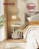 A bedside table with a lamp, books, and a storage basket next to a bed. Anteprima dell’immagine prodotto