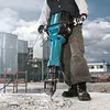 A person is using a demolition hammer on a concrete surface at a construction site. Anteprima dell’immagine prodotto