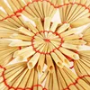 A close-up view of straw stars, a type of Christmas ornament, arranged in a circular pattern. Produktbild-Vorschau
