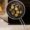 A frying pan with food cooking on a stovetop. Náhľad obrázku produktu
