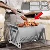 Silberner tragbarer Holzkohlegrill mit darauf gegartem Essen, eine Person mit Zange, und zerlegte Grillteile oben rechts Anteprima dell’immagine prodotto