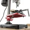 A close-up view of a drill press table with a vise and a piece of wood being held in place. Produktbild-Vorschau