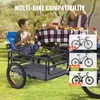 A family is having a picnic outdoors with a bicycle trailer in the foreground. Podgląd zdjęcia produktu