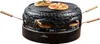 A black pizza oven with wooden handles and two small pizzas on top and two inside. Produktbild-Vorschau