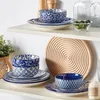 A set of blue and white patterned ceramic dishes is displayed on a white shelf. Produktbild-Vorschau