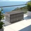 A wicker storage box sits on a balcony overlooking the ocean. Náhled obrázku produktu